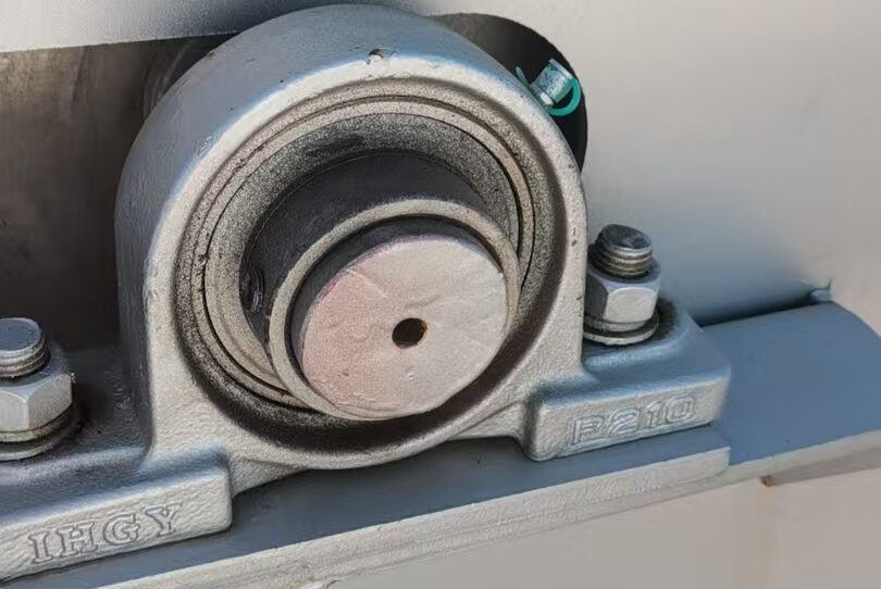 A close-up of a pillow block bearing mounted on a machine